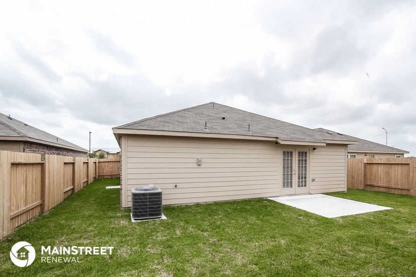 the backyard of a house with a yard and a chain link fence