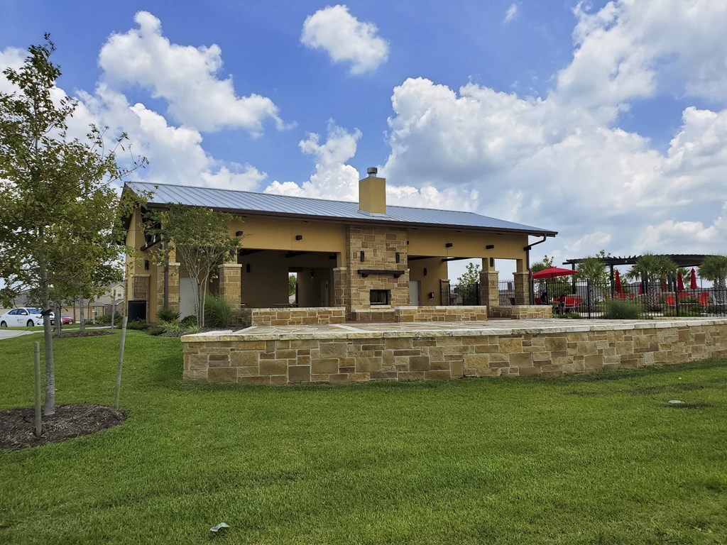 a house with a stone patio and a grassy yard