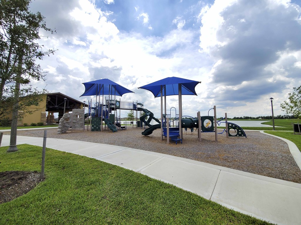 a playground with a play set and umbrellas