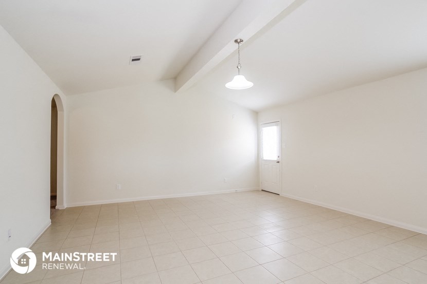 an empty living room with white walls and a white tile floor