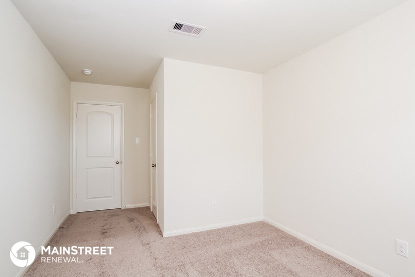 a bedroom with white walls and carpet and a white door