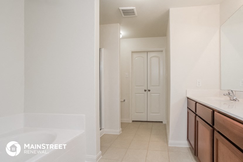 a bathroom with a sink and a bath tub and a closet