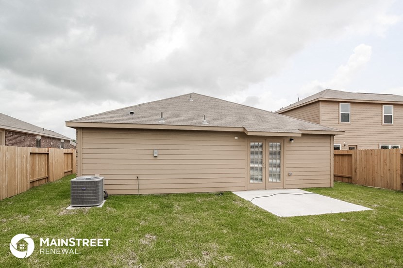 the front of a house with a yard and a fence