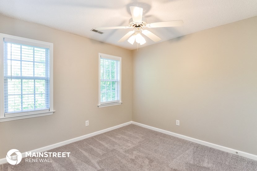 the master bedroom has a ceiling fan and two windows