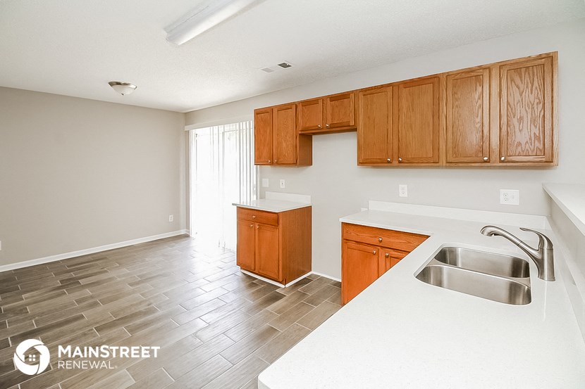 a kitchen with wooden cabinets and a white counter top