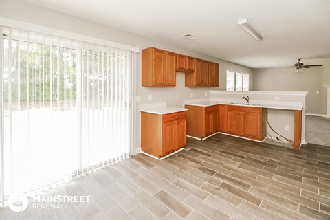 a kitchen with wooden cabinets and a large window