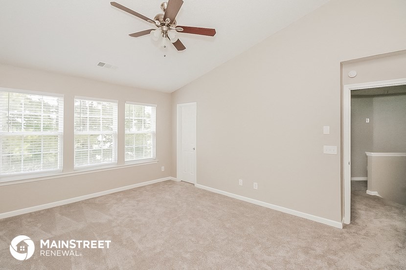 the living room of a home with a ceiling fan