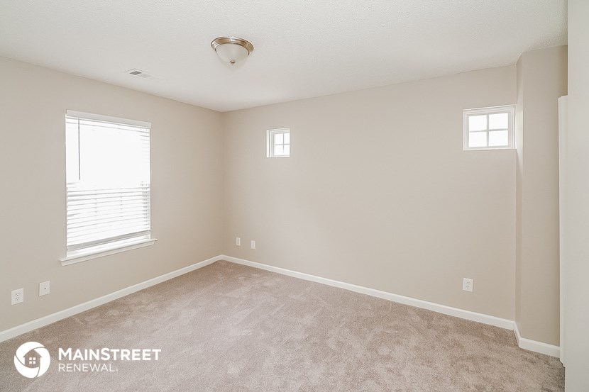 a bedroom with a carpeted floor and a window