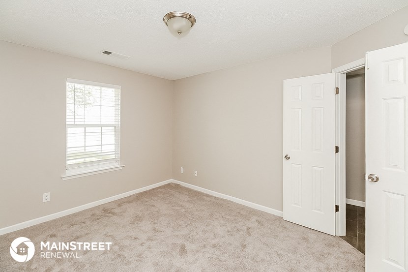 a bedroom with a carpeted floor and a white door