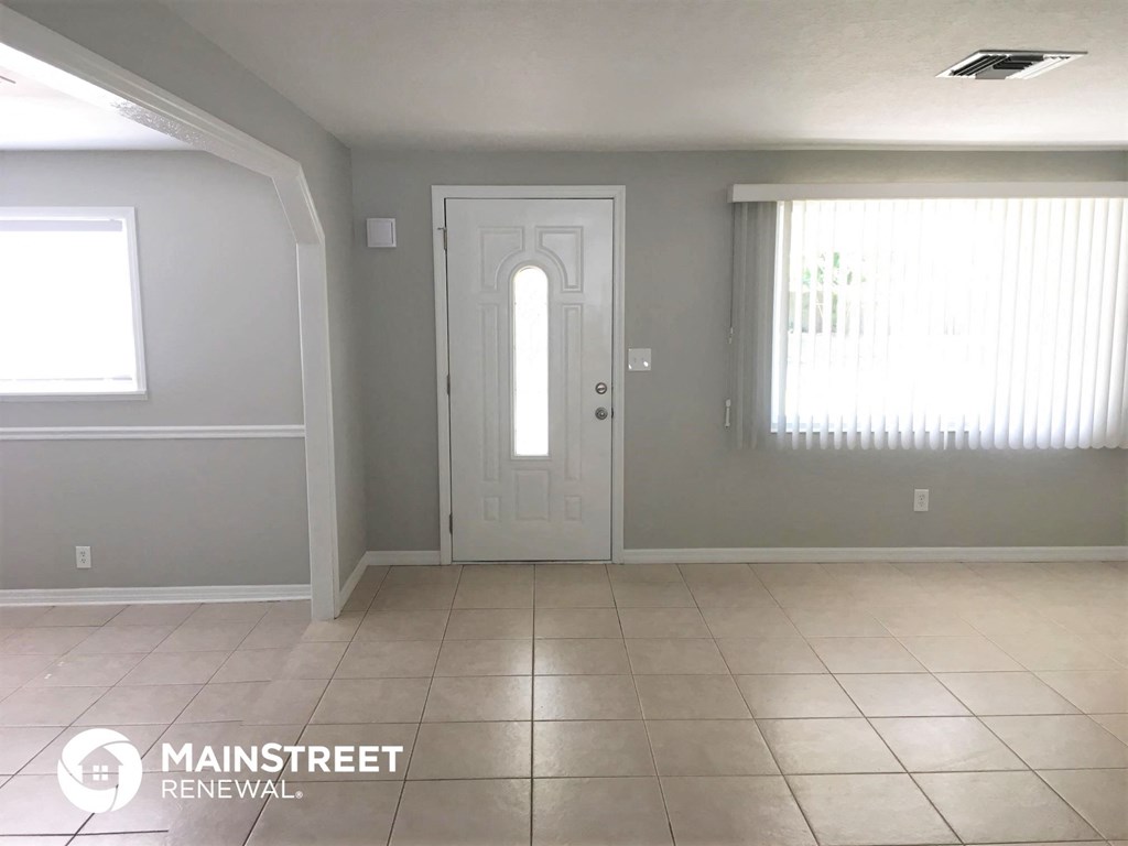 an empty living room with gray walls and a white door