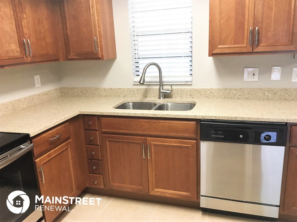 a kitchen with wooden cabinets and a stainless steel dishwasher