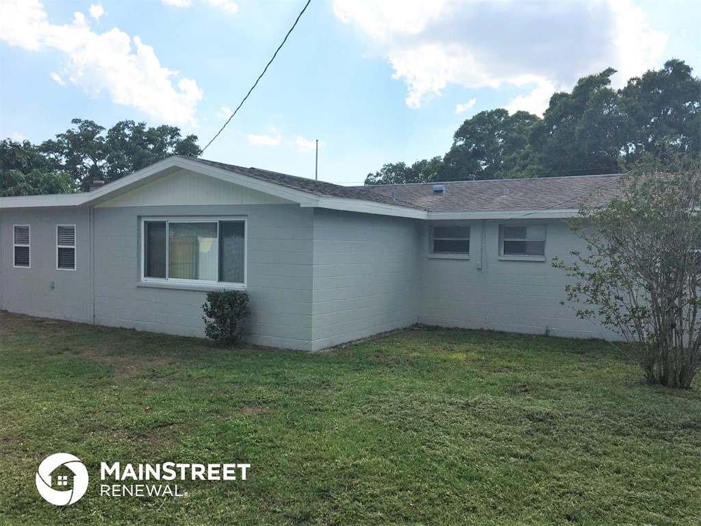 the front of a white house with a grass yard