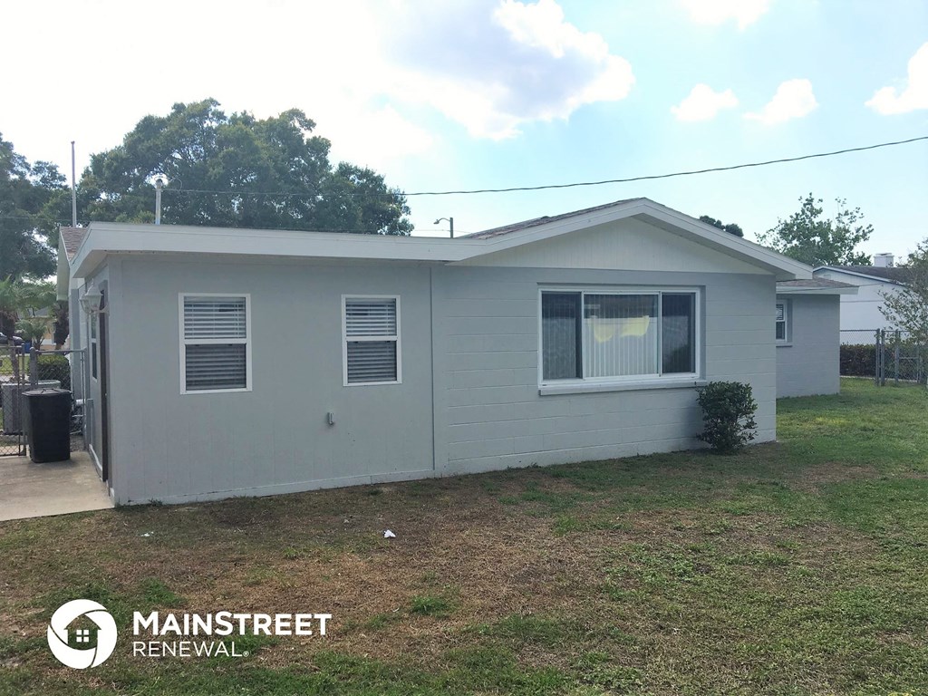 the front view of a small white house with a yard