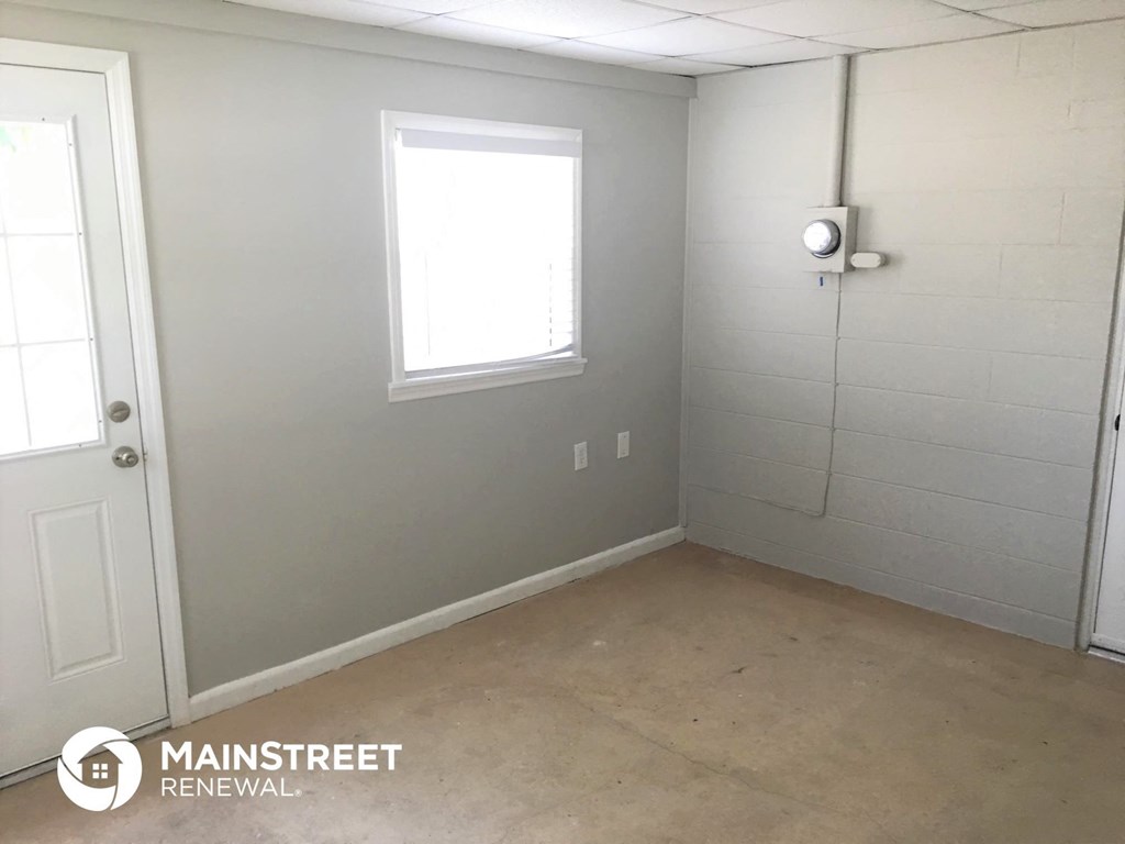 an empty room with a door and a window