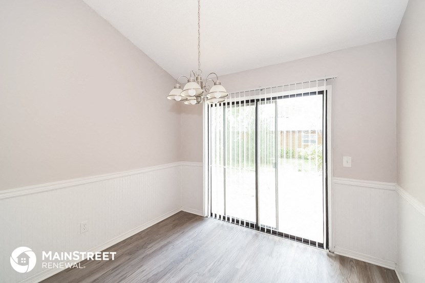 an empty living room with sliding glass doors to a patio
