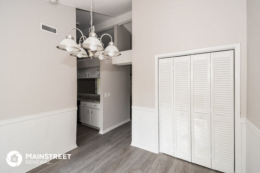 a kitchen with white cabinets and a large white closet