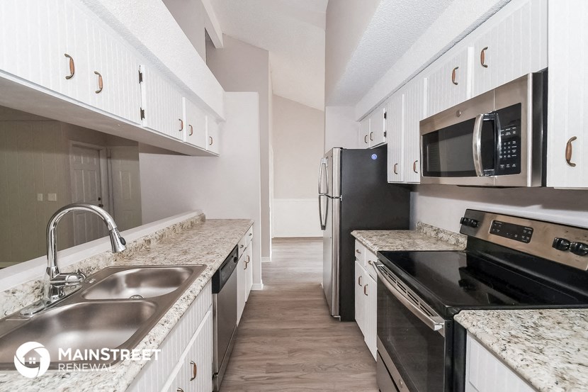 a kitchen with white cabinets and black appliances and granite counter tops