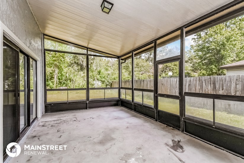 a conservatory with large windows and a concrete floor