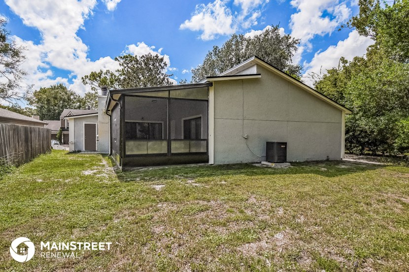 the backyard of a house with a grassy yard and some trees