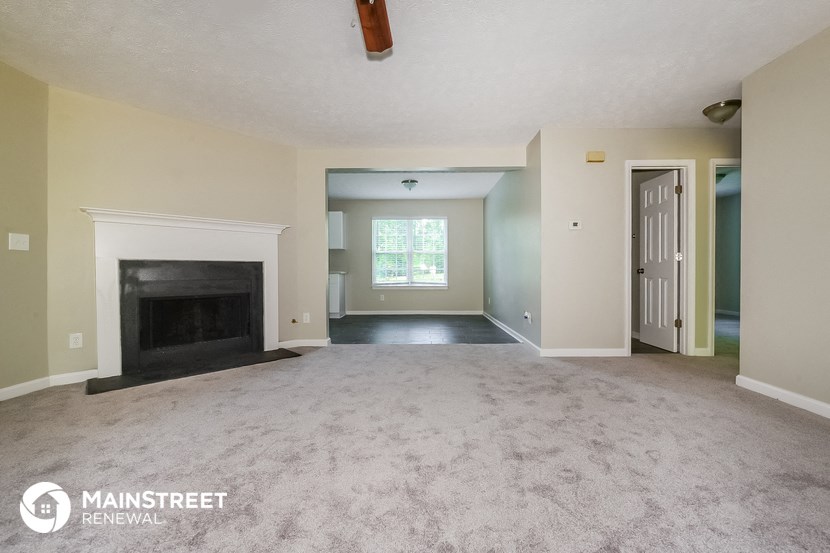 the living room of an empty house with a fireplace