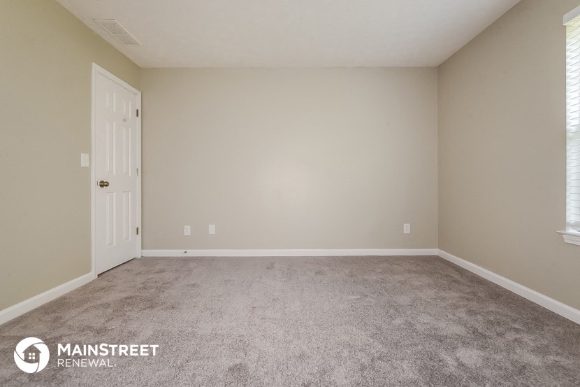 the upstairs bedroom has a carpeted floor and a white door