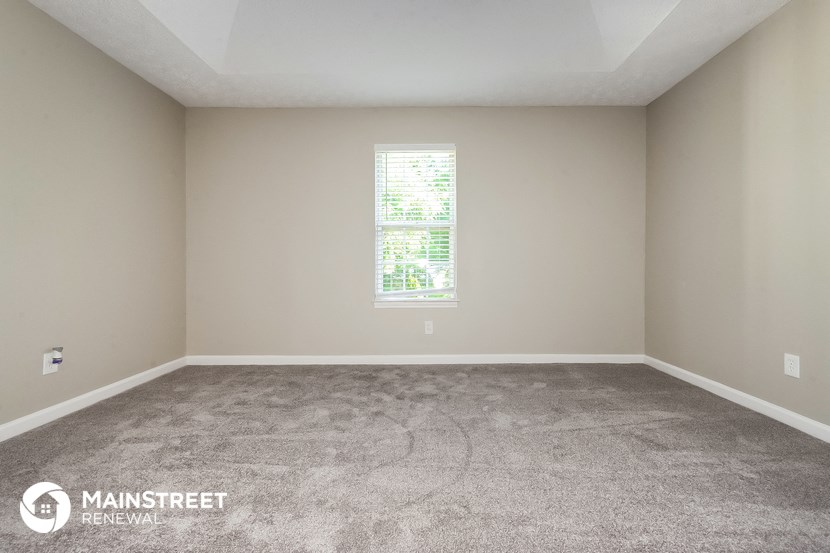 an empty room with carpet and a window
