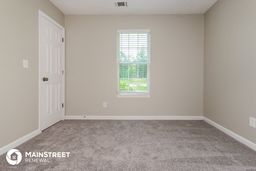 a room with carpet and a window and a door