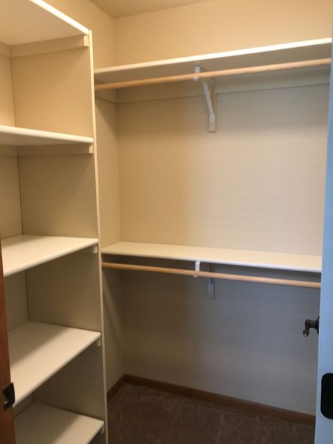 a walk in closet with empty shelves