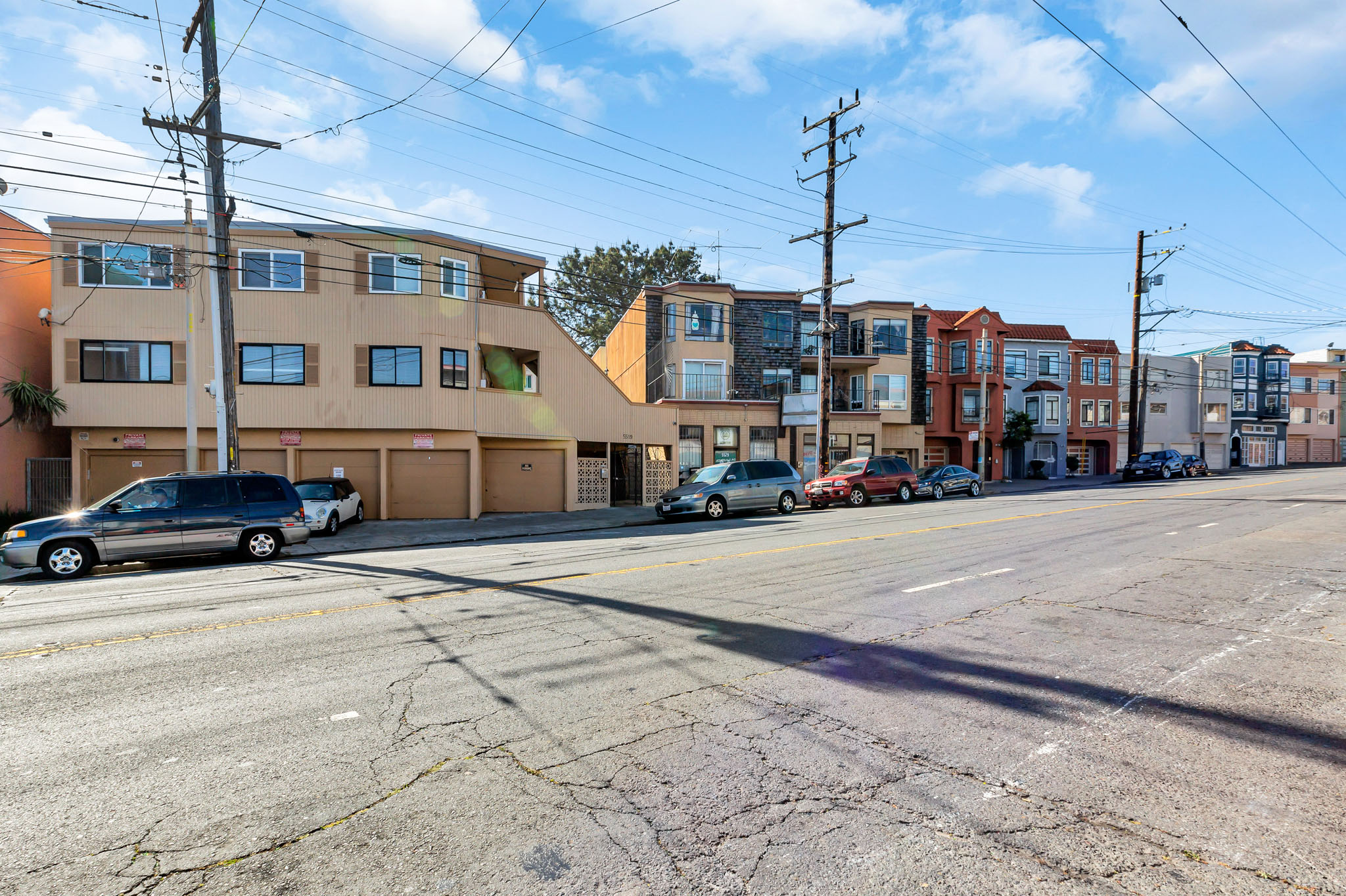 a city street with cars parked in front of buildings