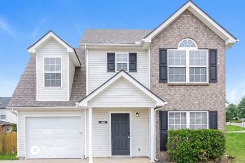 a white house with black shutters and a garage door