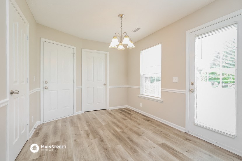 the living room of a home with white doors and a wood floor