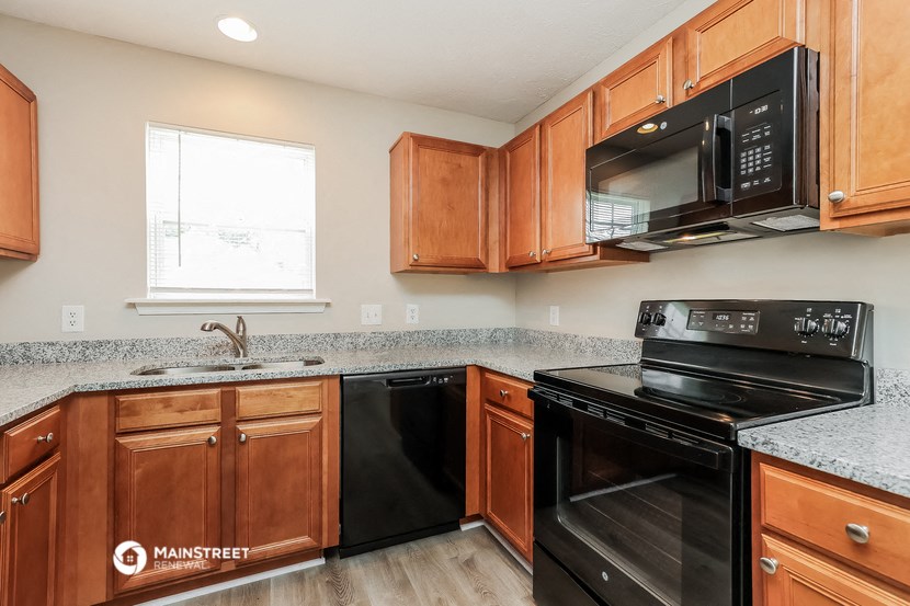 a kitchen with black appliances and granite counter tops and wooden cabinets