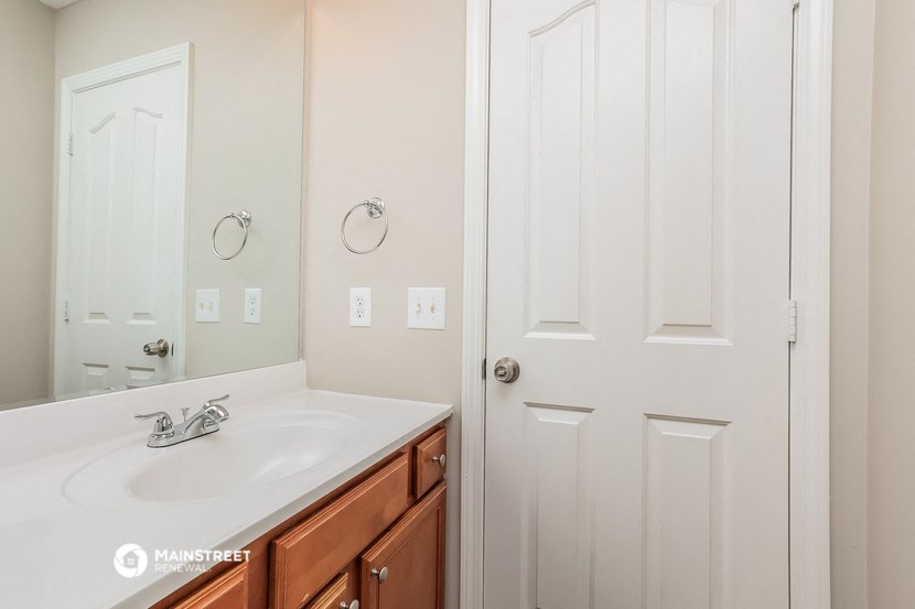 a bathroom with a sink and a mirror and a white door