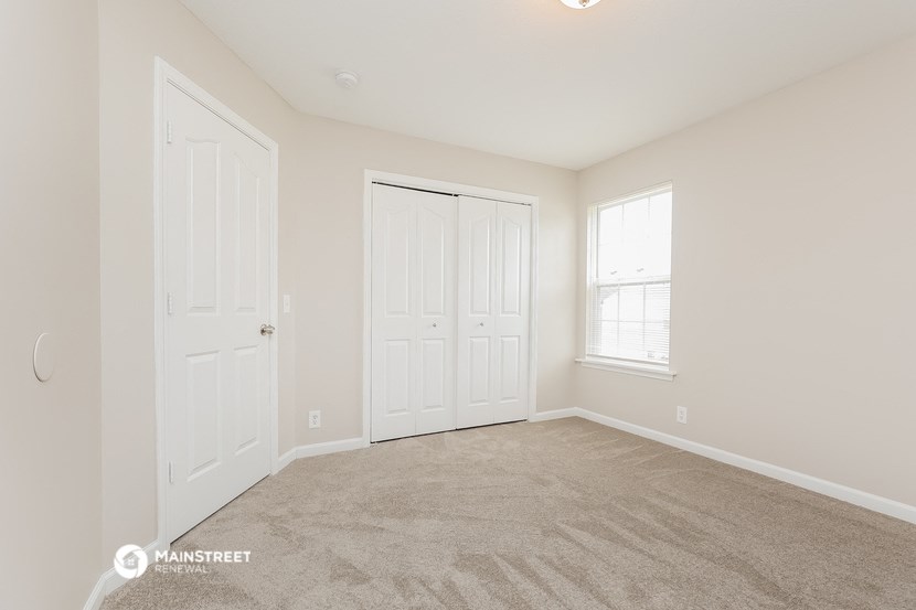 a bedroom with two doors and a carpeted floor