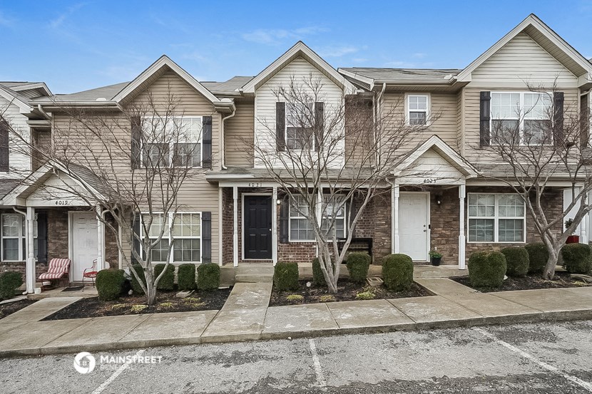 a brick house with a sidewalk in front of it