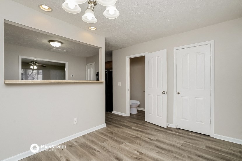 the living room and entrance into the bathroom of an apartment