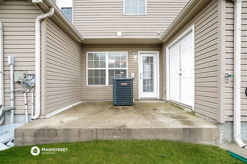 the front porch of a house with a trash can on it