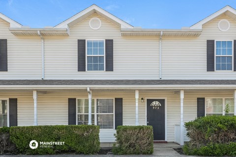 a white house with black shutters and a black door