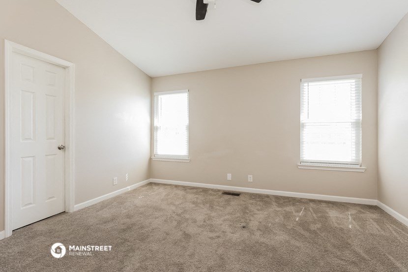 a room with carpet and a white door and window