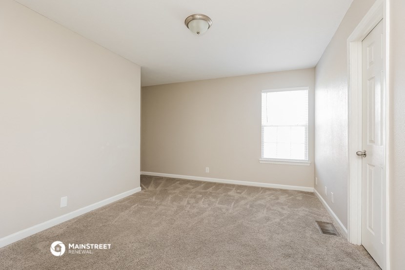 an empty room with carpet and a window