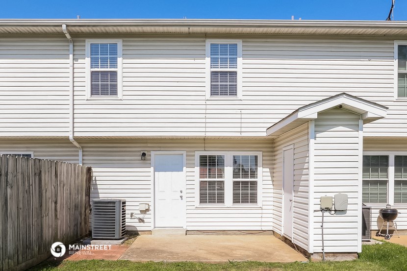 a white house with a white door and a wooden fence