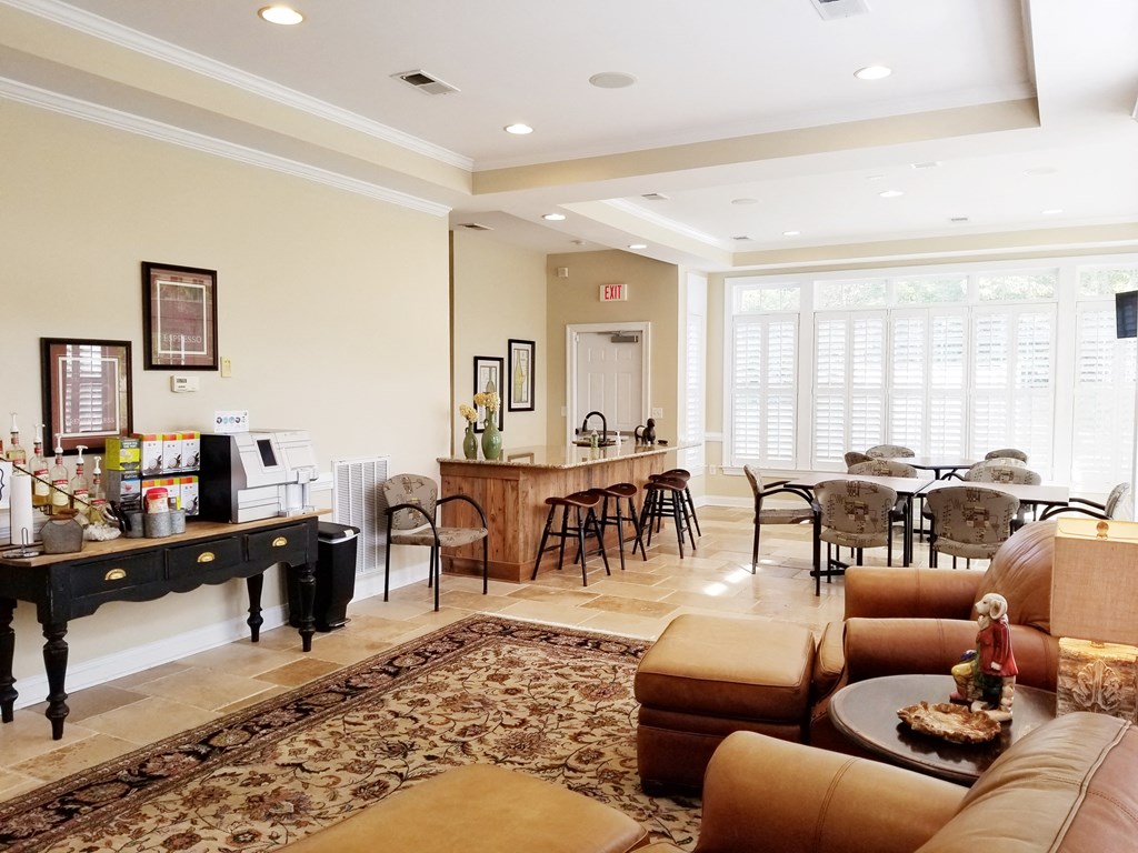 a living room with couches and a bar and a dining room with a kitchen