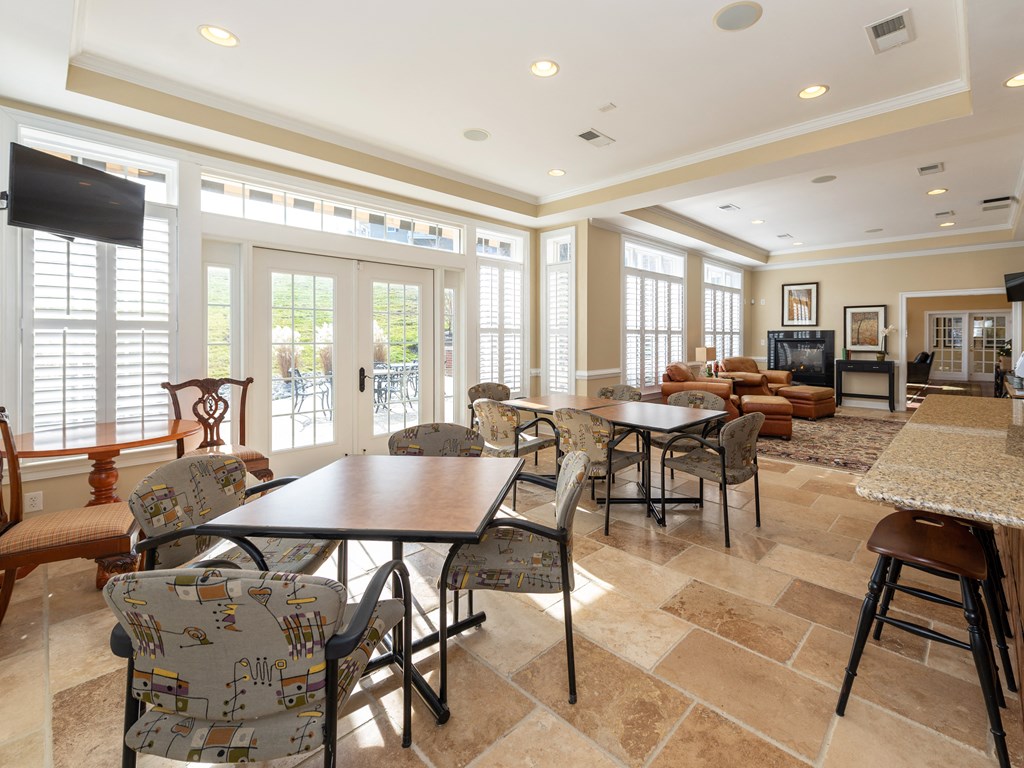 a dining room with tables and chairs and a living room with a tv