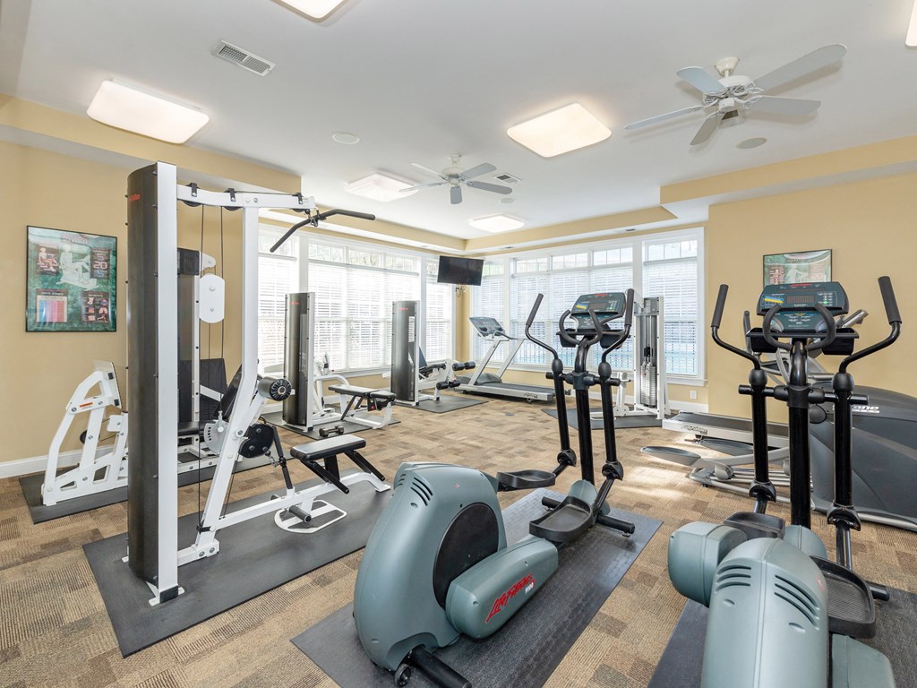 a gym with weights and other exercise equipments and a window