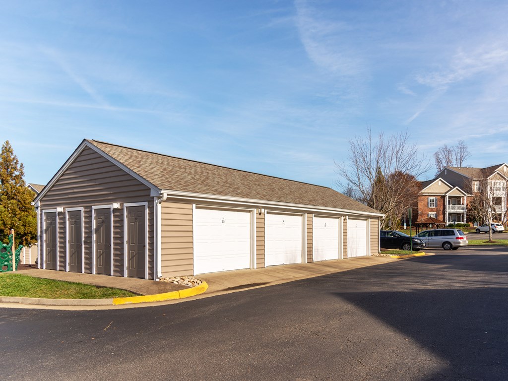 a garage with two white doors on the side of a street