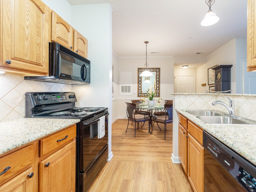 a kitchen with wooden cabinets and appliances and a dining room with a table