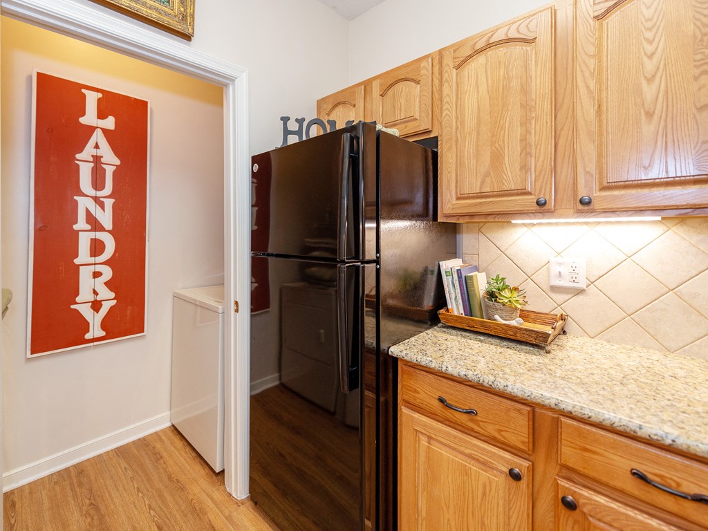 a kitchen with wood cabinets and a black refrigerator