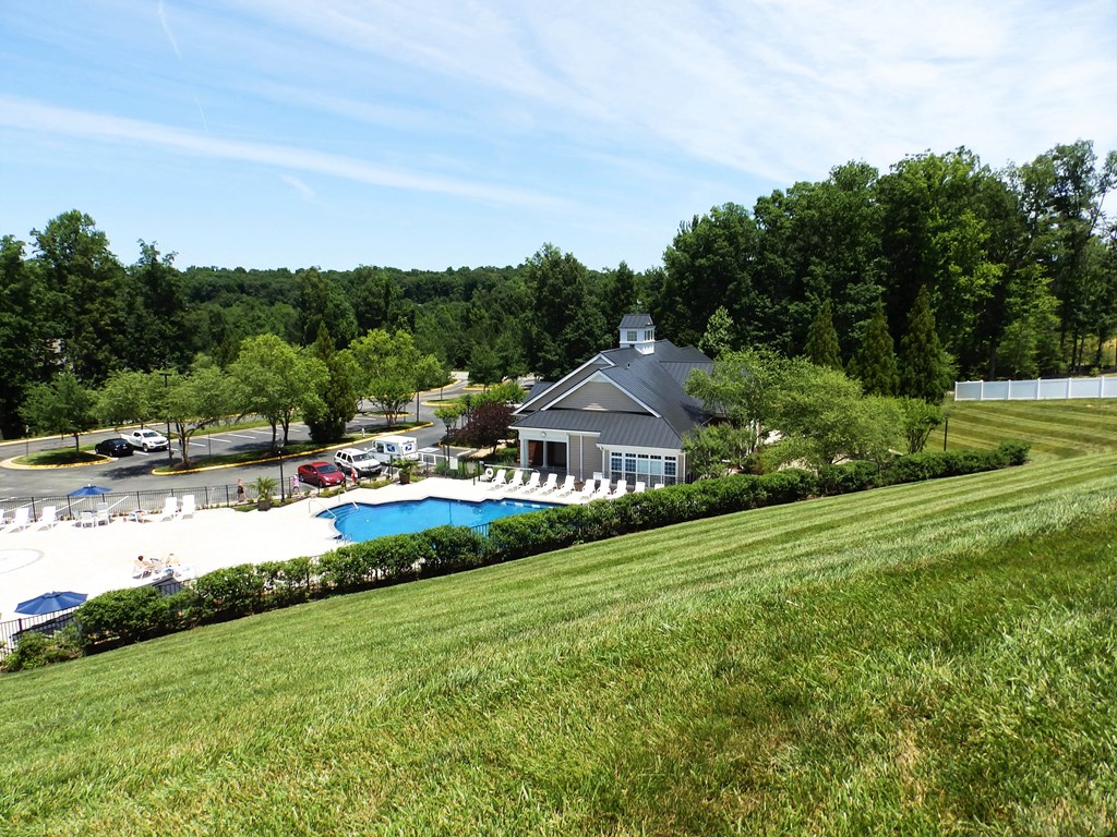 a view of the pool and a house from a hill