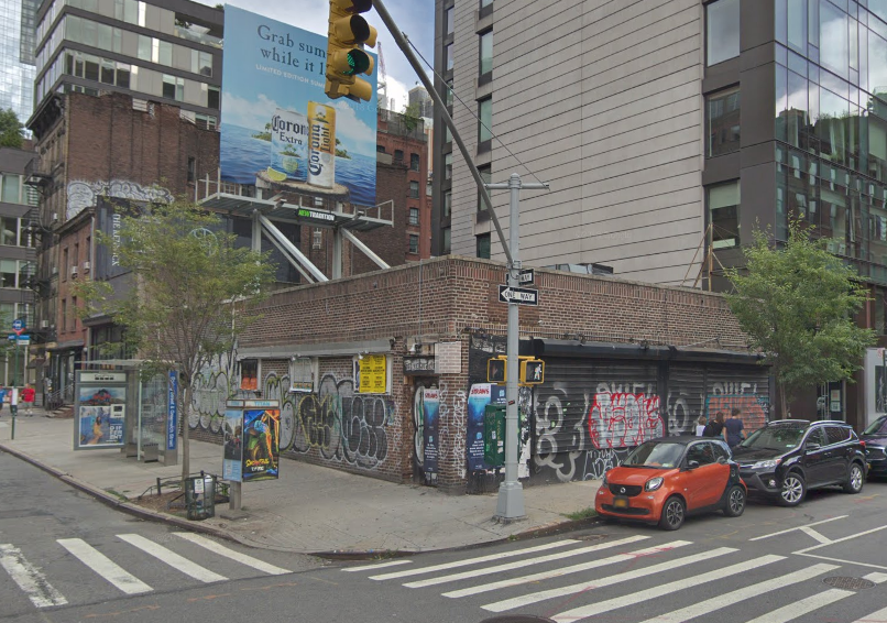 a brick building with graffiti on the side of a city street