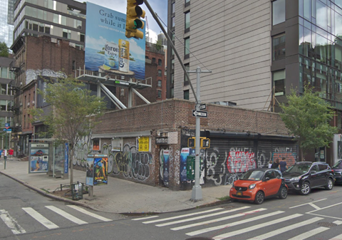 a brick building with graffiti on the side of a city street